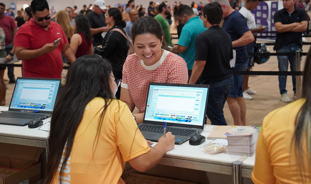 Voluntários entregando medalhas aos corredores na Corrida do Pantanal em Campo Grande.
