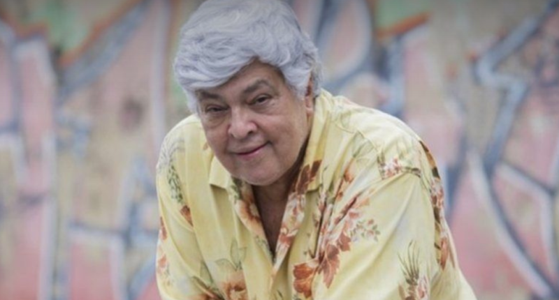 Sidney Magal canta ao vivo com banda e luzes vibrantes durante o show “Baile do Magal”.