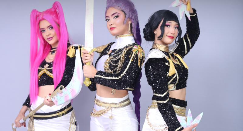 Elenco das Guerreiras Mágicas do K-Pop em apresentação cheia de luzes, figurinos vibrantes e coreografias inspiradas na cultura pop coreana.