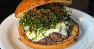 Lanche Quatro Formaggio do NaBrasa Burger com burger defumado, creme quatro queijos, couve crispy e pão de brioche.