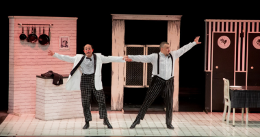 Cena colorida da IX Pantalhaç@s com artistas em movimento, luz quente, figurinos expressivos e atmosfera circense que celebra humor, memória e poesia.