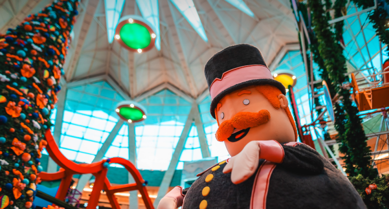 Cenografia colorida do Natal do Bita no Bosque dos Ipês, com roda-gigante indoor iluminada e área interativa que recebe famílias durante o mês de dezembro.