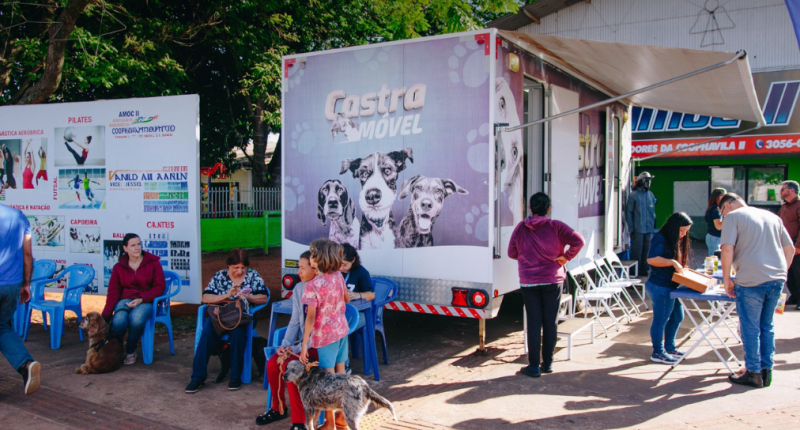 “Equipe do Castramóvel realizando atendimentos gratuitos para cães e gatos, com tutores em fila e estrutura do CCZ montada no local.”