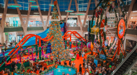 Decoração natalina no Shopping Bosque dos Ipês com famílias circulando e atrações infantis.