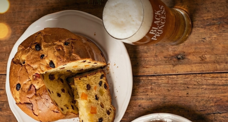 Taça de cerveja escura harmonizada com sobremesa natalina sobre mesa decorada