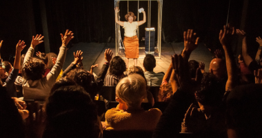 Atriz Vanderleia Will em cena como a palhaça de Desajustada, iluminada no palco, expressando emoção e humor em movimento físico poético.