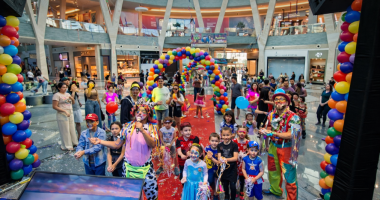 Crianças fantasiadas participando de bailinho de Carnaval em ambiente colorido e familiar na Praça Central do Shopping Bosque dos Ipês
