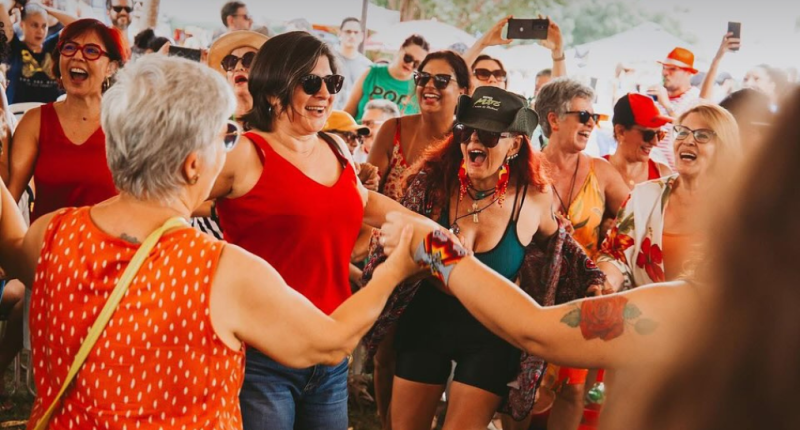 Bancas coloridas com artesanato, gastronomia e público circulando na Praça do Coophafé durante a Feira Borogodó em Campo Grande