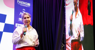 Mulheres participando de painel sobre liderança e empreendedorismo em evento corporativo com ambiente moderno e inspirador