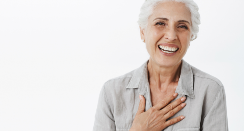 Mulher idosa sorrindo representando cuidados com a saúde da mulher após os 60 anos