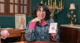 Escritora lendo poesia em café cultural durante encontro literário em Campo Grande