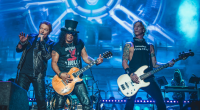Palco iluminado com público em show do Guns N’ Roses durante apresentação de rock internacional