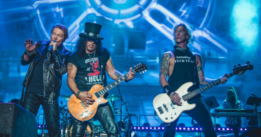 Palco iluminado com público em show do Guns N’ Roses durante apresentação de rock internacional