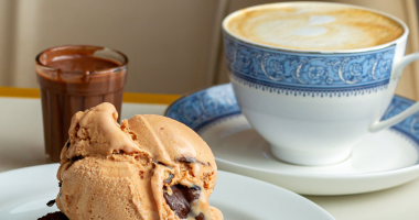 Cappuccino cremoso servido com brownie de chocolate meio amargo e gelato de doce de leite em ambiente aconchegante de cafeteria