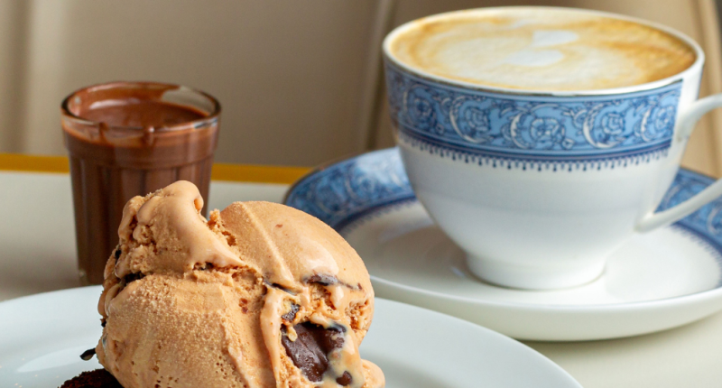 Cappuccino cremoso servido com brownie de chocolate meio amargo e gelato de doce de leite em ambiente aconchegante de cafeteria