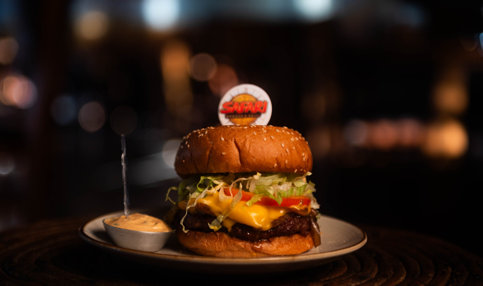 Hambúrguer artesanal de ponta de costela com cheddar derretido e cebola caramelizada servido em pão macio no Safari Burger