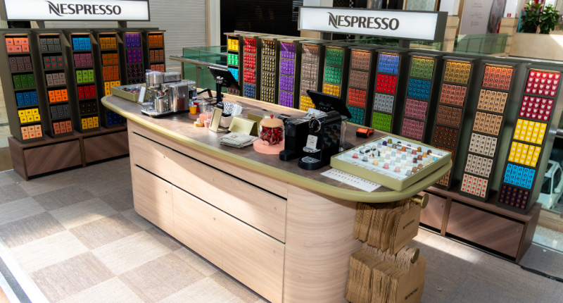 Boutique Nespresso com exposição de cápsulas e máquinas em ambiente sofisticado de café
