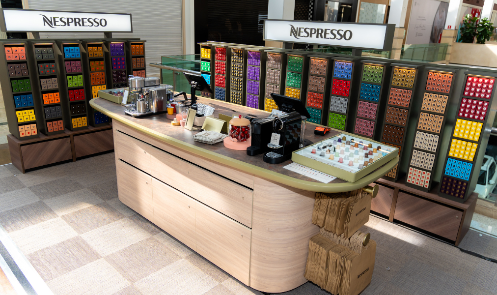 Boutique Nespresso com exposição de cápsulas e máquinas em ambiente sofisticado de café