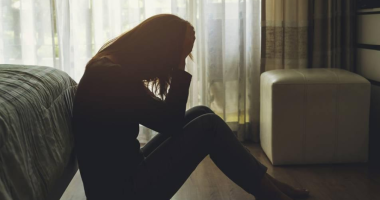 Mulher em momento de reflexão com luz suave representando saúde mental feminina e equilíbrio emocional