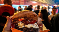 público e hamburguer reunido em festival gastronômico com hambúrgueres artesanais sendo preparados em chapas ao ar livre