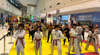 crianças e adultos participando de aula de artes marciais em shopping com ambiente familiar