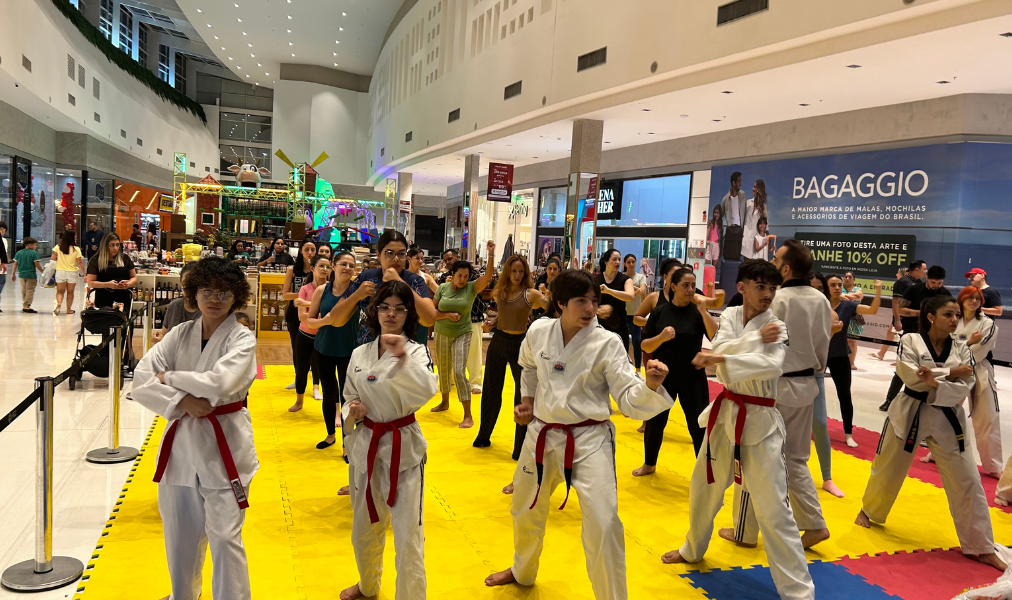 crianças e adultos participando de aula de artes marciais em shopping com ambiente familiar