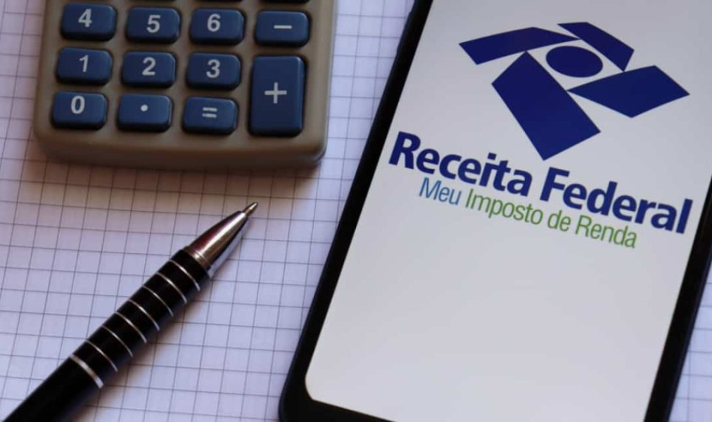 Atendimento de orientação fiscal com profissionais auxiliando contribuinte na declaração do imposto de renda