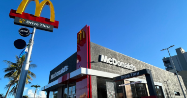 fachada moderna do McDonald’s com drive-thru e iluminação noturna em cidade do interior