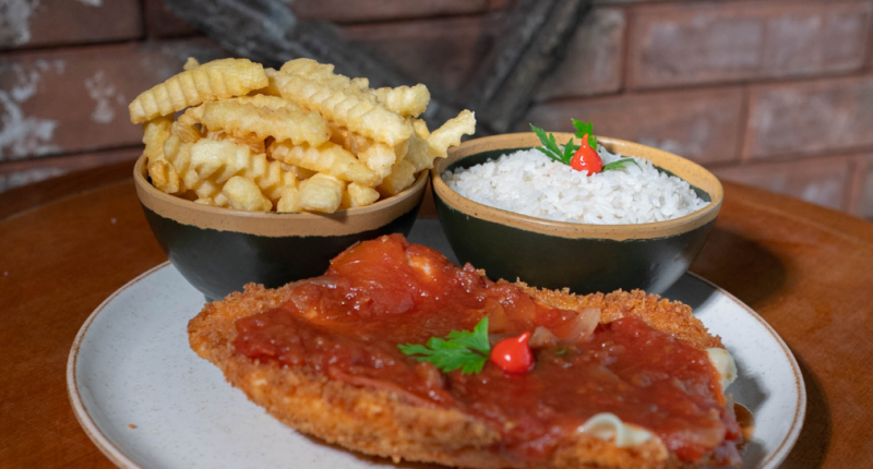 prato de parmegiana servido com arroz branco e batatas fritas, com molho de tomate e queijo derretido em destaque