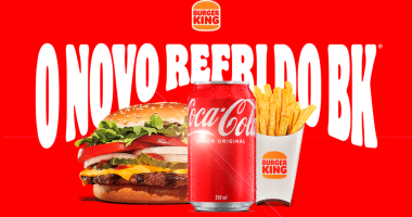 Lata de Coca-Cola ao lado de hambúrguer e batata frita em divulgação