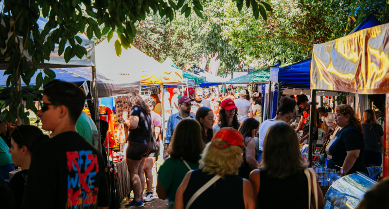 Público circula entre barracas de economia criativa durante edição da Feira Borogodó em Campo Grande, com apresentações culturais e clima de celebração.