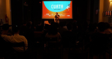 diretor conversa com público durante festival de cinema em auditório com projeção de curta-metragem