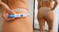 Mulher observa mudança no contorno corporal enquanto segura caneta injetável usada em tratamentos para emagrecimento