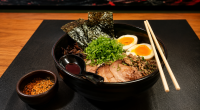 Tigela de lamen japonês fumegante servida em restaurante durante período de frio em Campo Grande.