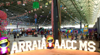 Público circulando entre barracas de comidas típicas durante o Arraiá da AACC/MS, em Campo Grande, em uma grande festa junina solidária.