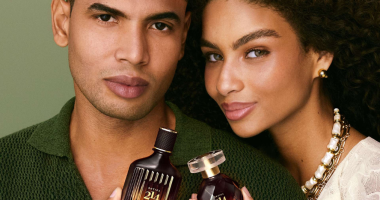 Casal posa segurando fragrâncias Botica 214 Arabian Oasis, lançamento de O Boticário para o Dia dos Namorados, destacando a perfumaria premium inspirada em viagens sensoriais.