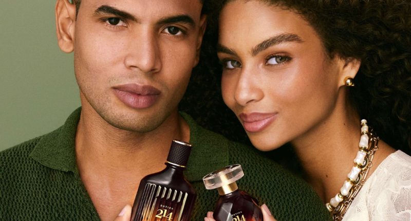 Casal posa segurando fragrâncias Botica 214 Arabian Oasis, lançamento de O Boticário para o Dia dos Namorados, destacando a perfumaria premium inspirada em viagens sensoriais.
