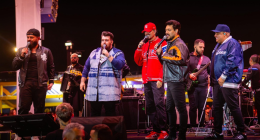 Artistas do projeto Cê Tá Doido durante show sertanejo com palco 360 graus.