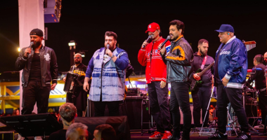 Artistas do projeto Cê Tá Doido durante show sertanejo com palco 360 graus.