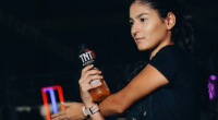 Corredores participam de prova de rua enquanto recebem hidratação em área de ativação da TNT Sport Drink durante evento esportivo