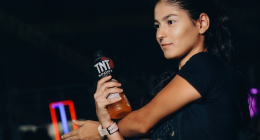 Corredores participam de prova de rua enquanto recebem hidratação em área de ativação da TNT Sport Drink durante evento esportivo