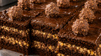 Fatia de bolo de chocolate artesanal com recheio cremosoe cobertura intensa durante o Festival de Fatias da Ala Wa Confeitaria Artesanal.