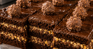 Fatia de bolo de chocolate artesanal com recheio cremosoe cobertura intensa durante o Festival de Fatias da Ala Wa Confeitaria Artesanal.