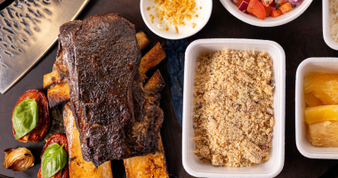 Costela bovina defumada da Fumatta servida com acompanhamentos artesanais, evidenciando a técnica de longa cocção e a gastronomia autoral desenvolvida em Campo Grande