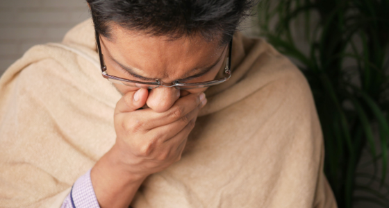 Pessoa utiliza garrafa de água e protege as vias respiratórias durante período de baixa umidade do ar.