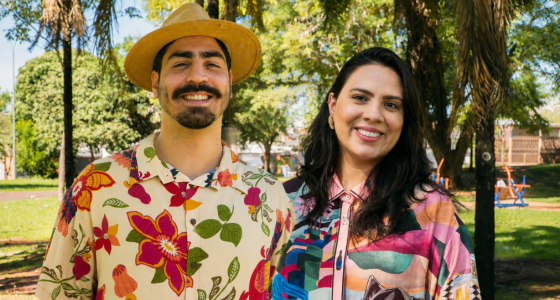 Felipe Monteiro e Jenny Benitez durante edição da Feira Borogodó, cercados por expositores, público e manifestações culturais em Campo Grande.