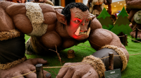 Escultura gigante de um orc em cenário temático montado nos corredores do Shopping Bosque dos Ipês durante exposição gratuita.