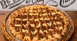pizza doce Banana Real com banana, chocolate branco, creme especial e canela servidas sobre mesa de madeira
