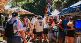 Visitantes circulam entre estandes da Feira Borogodó durante evento realizado na Praça Coophafé, em Campo Grande.
