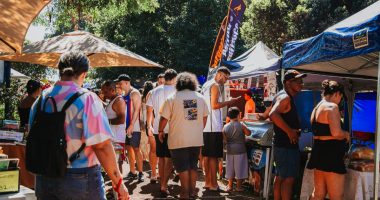 Visitantes circulam entre estandes da Feira Borogodó durante evento realizado na Praça Coophafé, em Campo Grande.